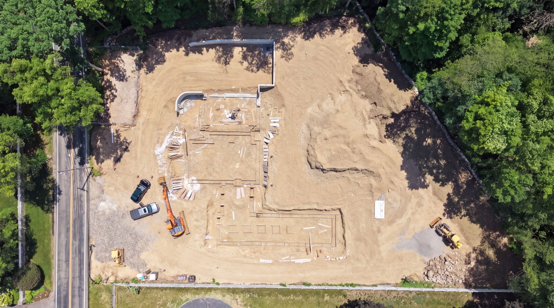 Aerial view of footing formwork set across the graded building pad.