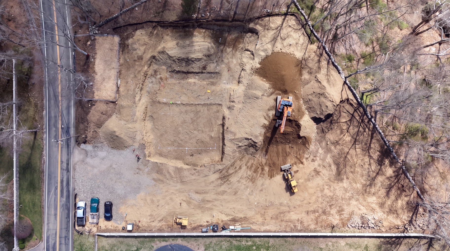 Aerial view of the excavated building pad with footing trenches laid out.