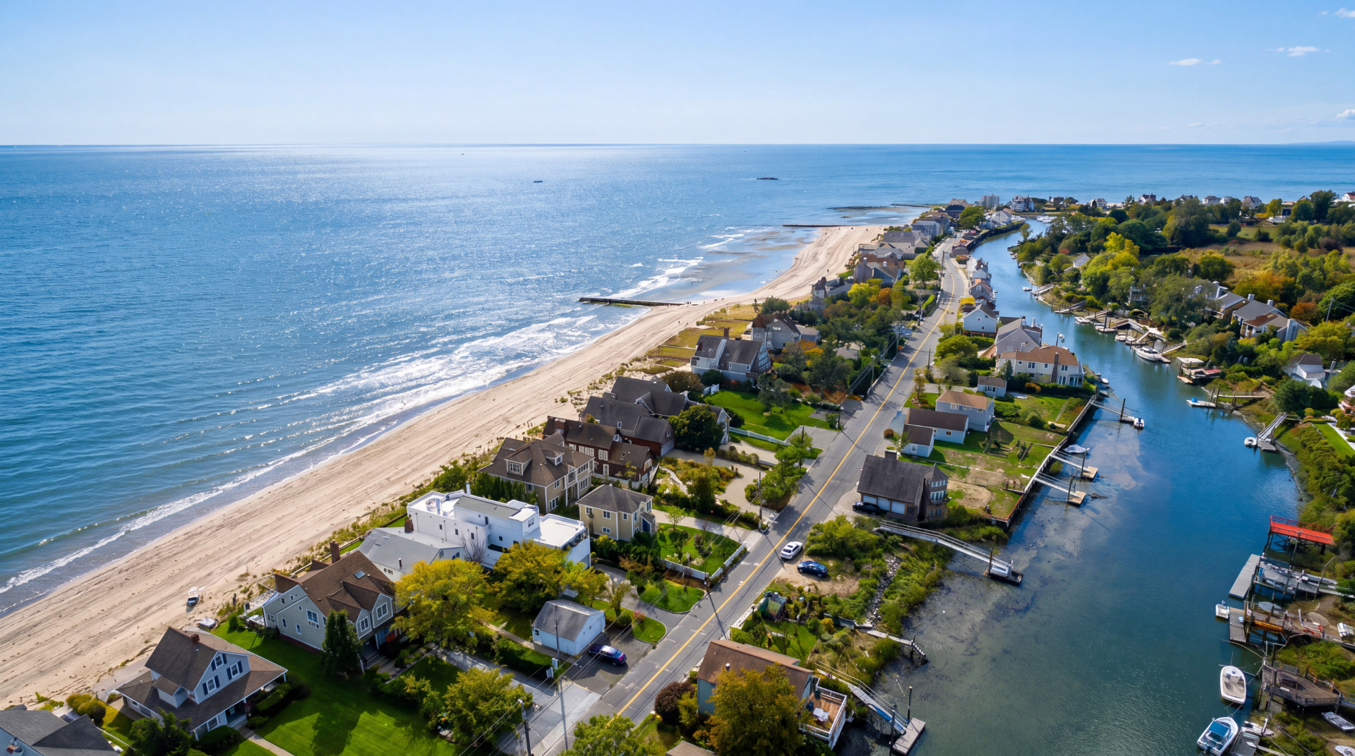 Aerial view of a Fairfield County, Connecticut coastal neighborhood between Long Island Sound beachfront and a tidal river.